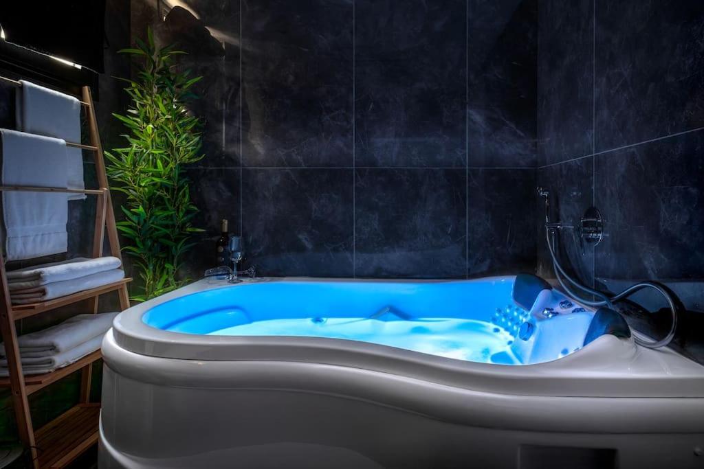 uma banheira numa casa de banho com uma banheira azul em סוויטה מרווחת, רומנטית ומפנקת em Eilat