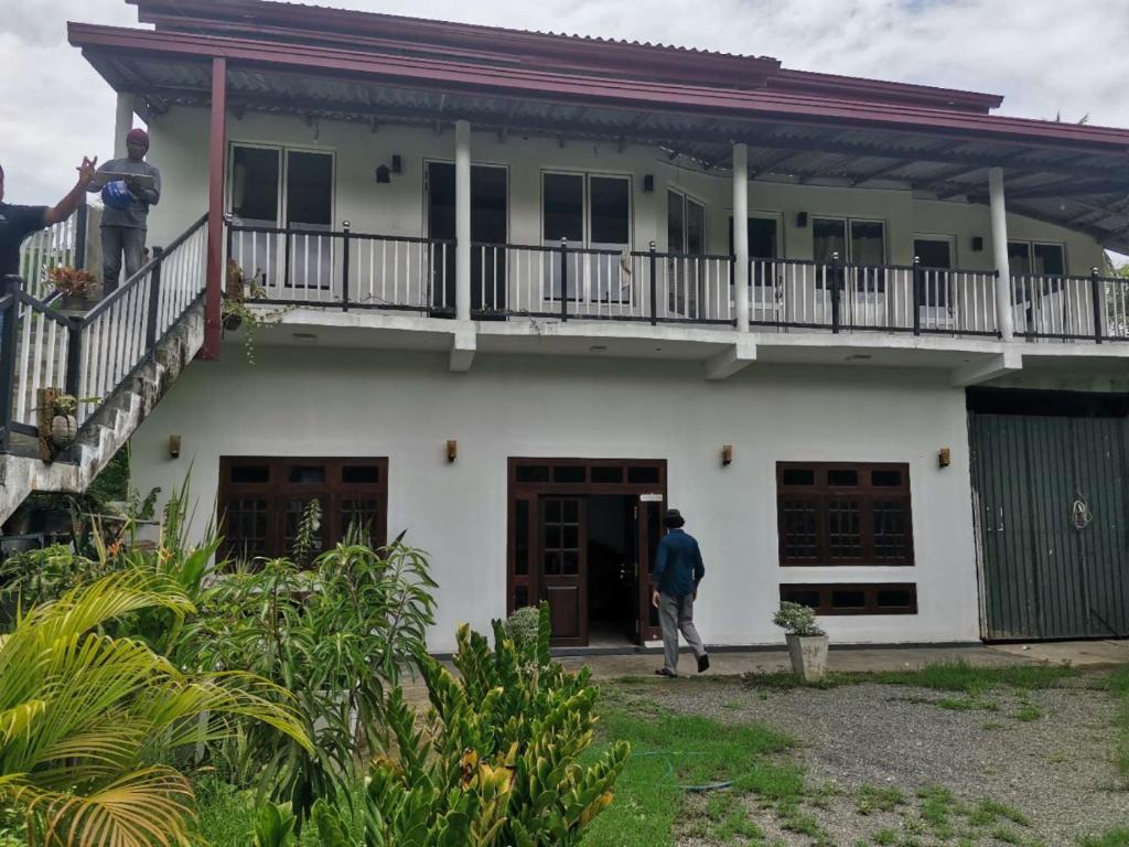 a man standing on the balcony of a house at Sunfa Resort in Ambalantota