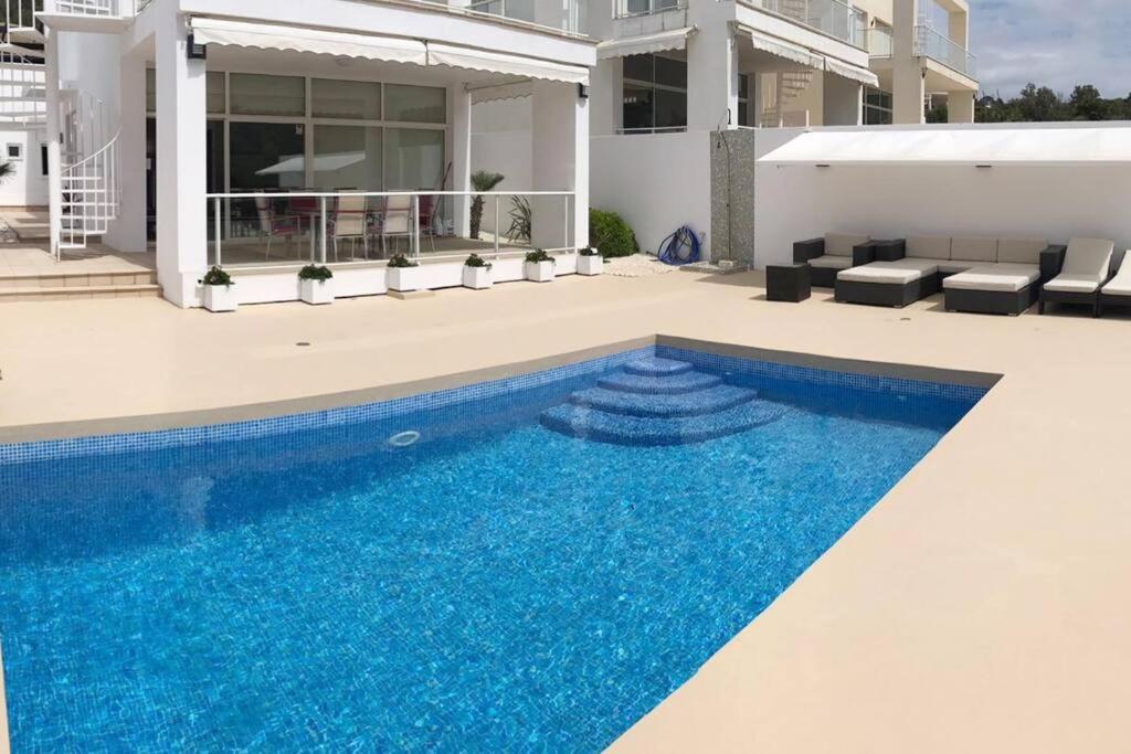 a swimming pool in front of a house at Chalet en C.Vadella - Piscina privada in Cala Vadella