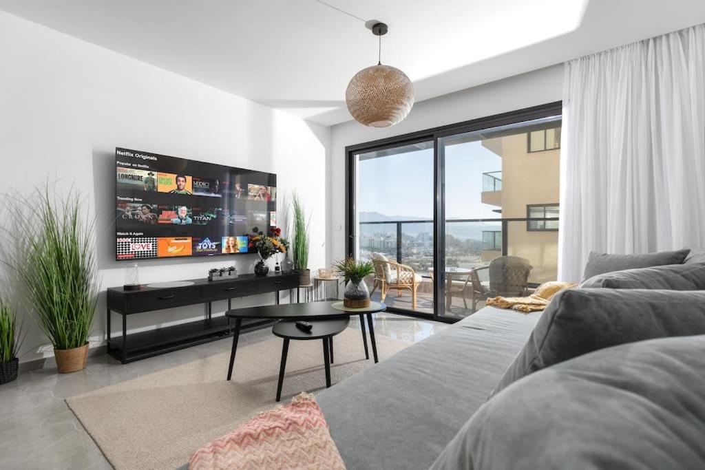 a living room with a couch and a tv at סוויטה מרווחת, רומנטית ומפנקת in Eilat