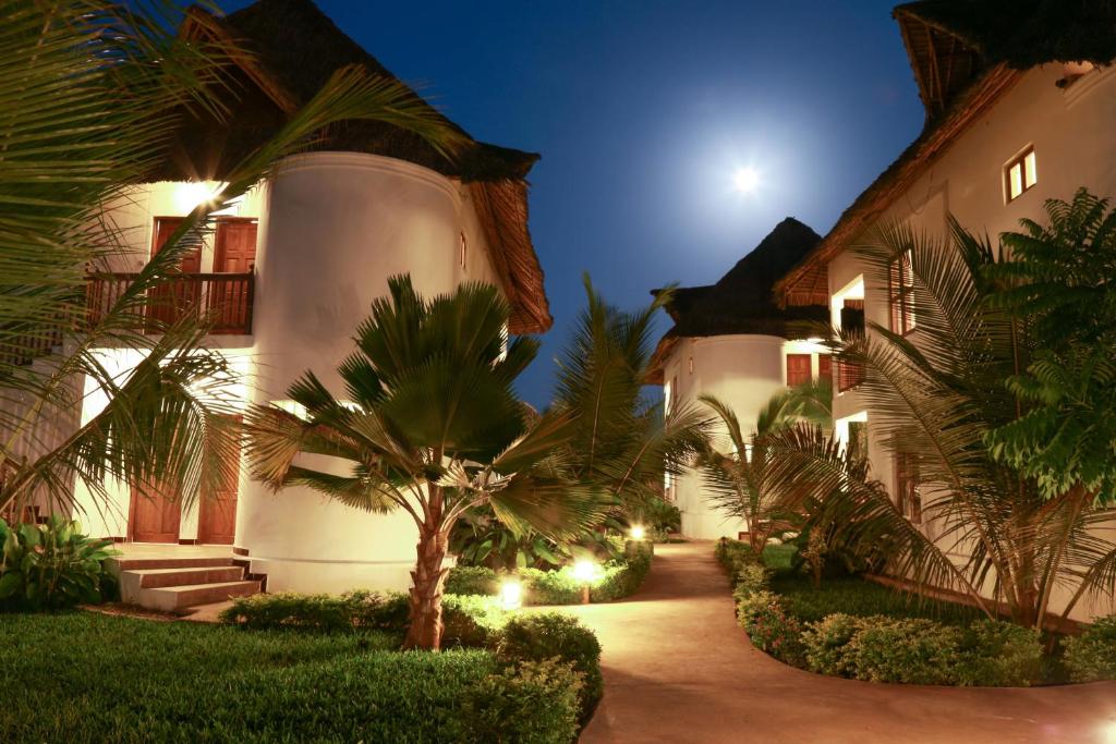 a house with a palm tree in front of it at Zanzibar Bahari Villas in Matemwe