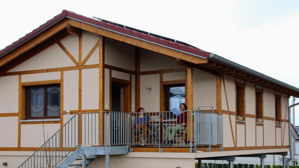 two people on the balcony of a house at Chalet Charmant-Santelmann in Bischoffingen