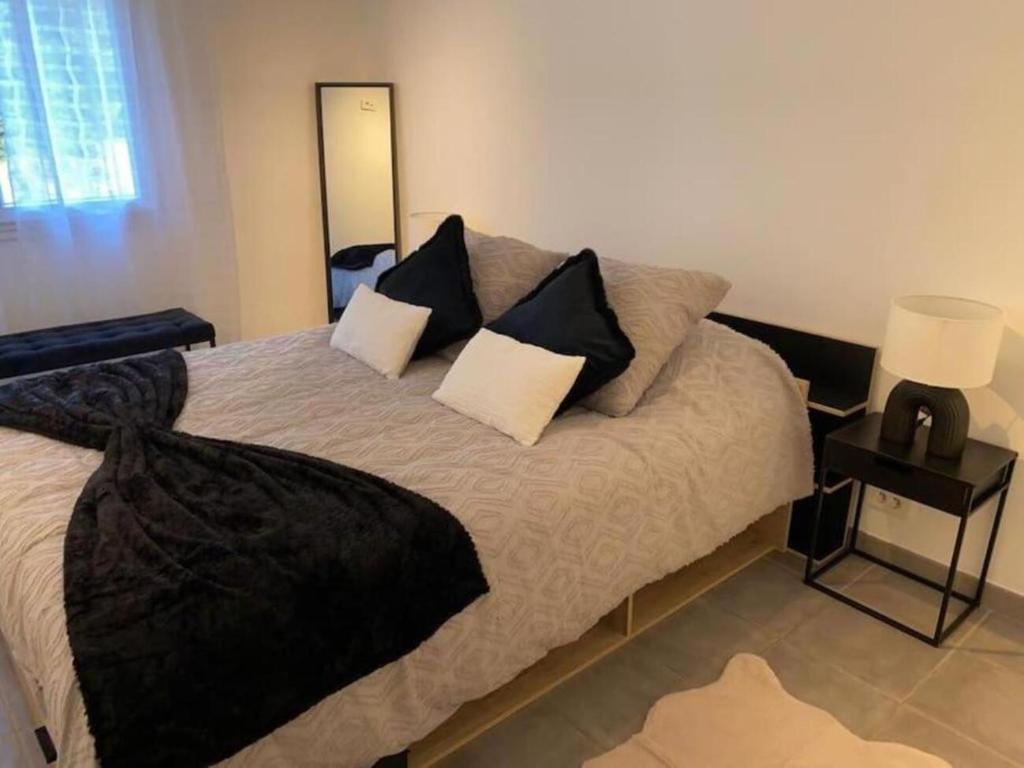 - une chambre avec un lit et des oreillers noirs et blancs dans l'établissement Charmant T3 en résidence privée, à Marseille