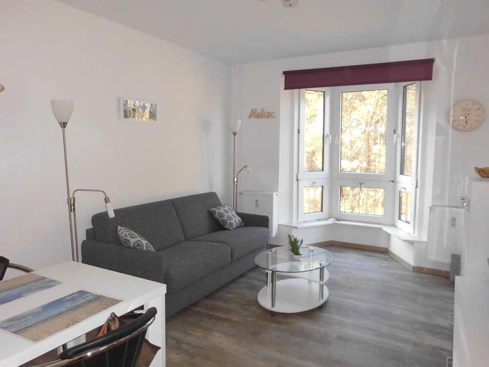 uma sala de estar com um sofá e uma mesa em Wohnung 59 em Ostseebad Karlshagen