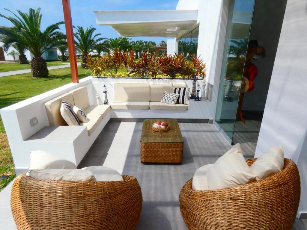 patio z 2 kanapami i stołem w obiekcie Casa de Playa Deluxe en Condominio Playa Coral w mieście Fundo Copacabana