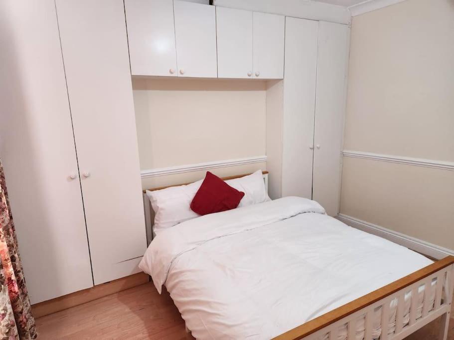 Dormitorio pequeño con cama con almohada roja en Comfy Guest House, en Londres