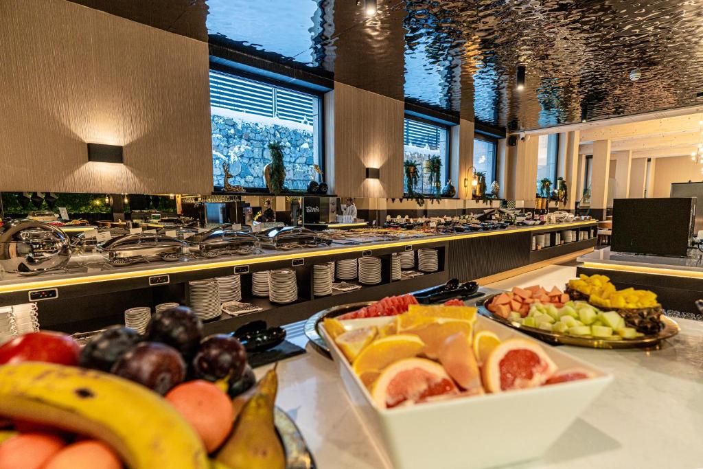Breakfast buffet spread with bowls of sliced fruit in foreground and chafing dishes along counter