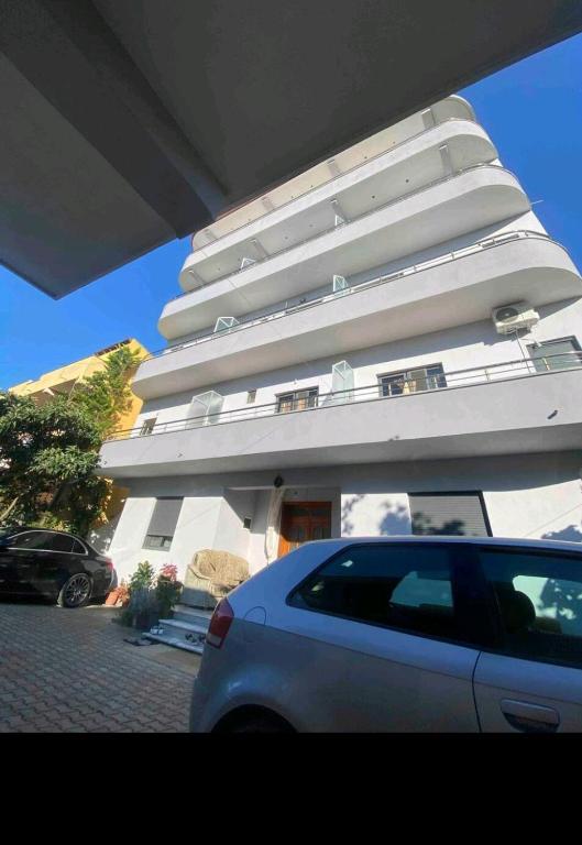 a white car parked in front of a building at Ajsi Apartments in Durrës