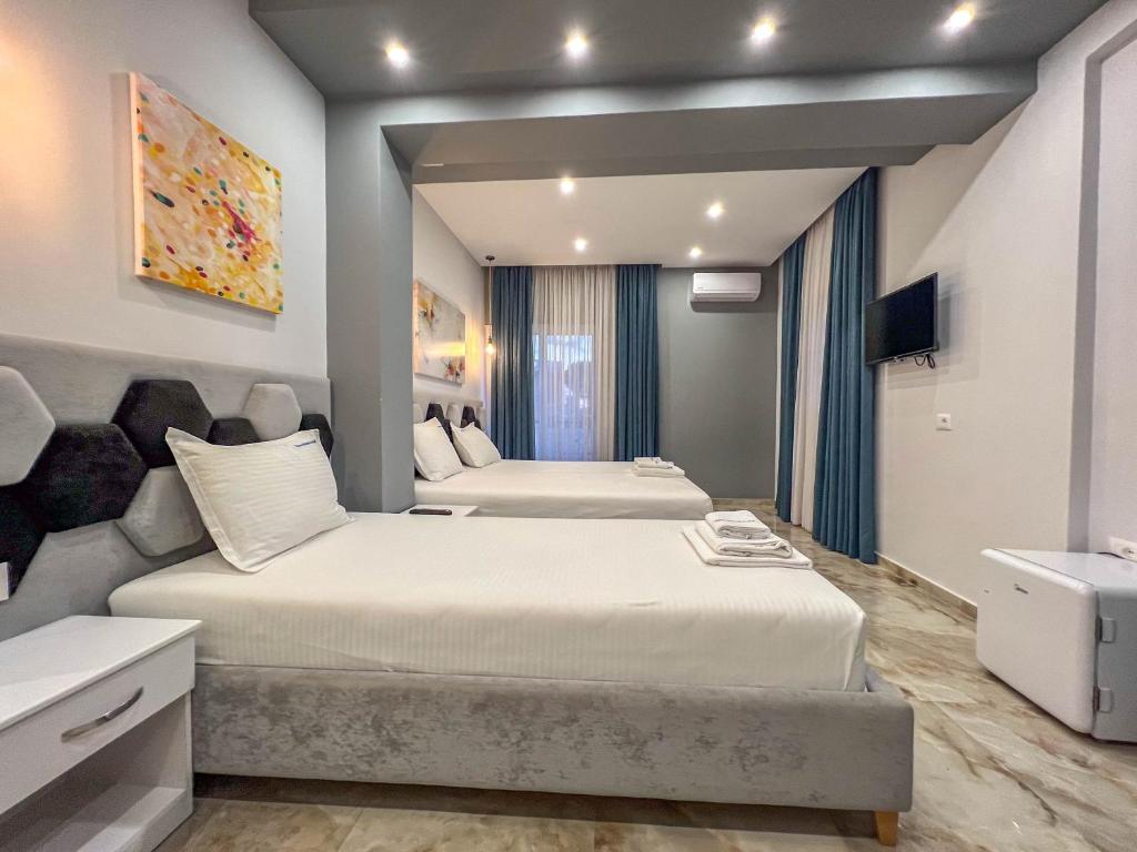 una camera con due letti e un lavandino di Rumani 3 Islands Hotel a Ksamil