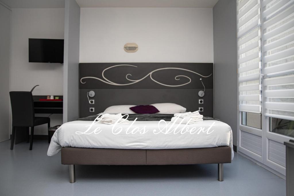 a bedroom with a bed with a black and white headboard at Le Clos Albert in Loudun