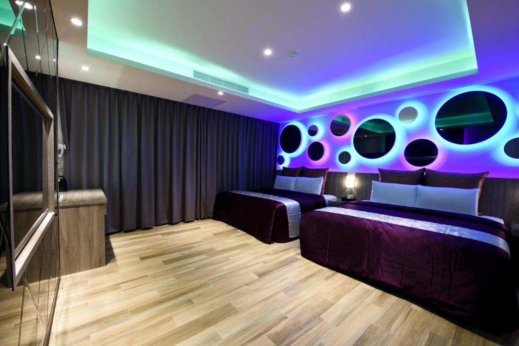 - une chambre avec 2 lits et un plafond violet dans l'établissement Meng Siang Motel, à Pingzhen