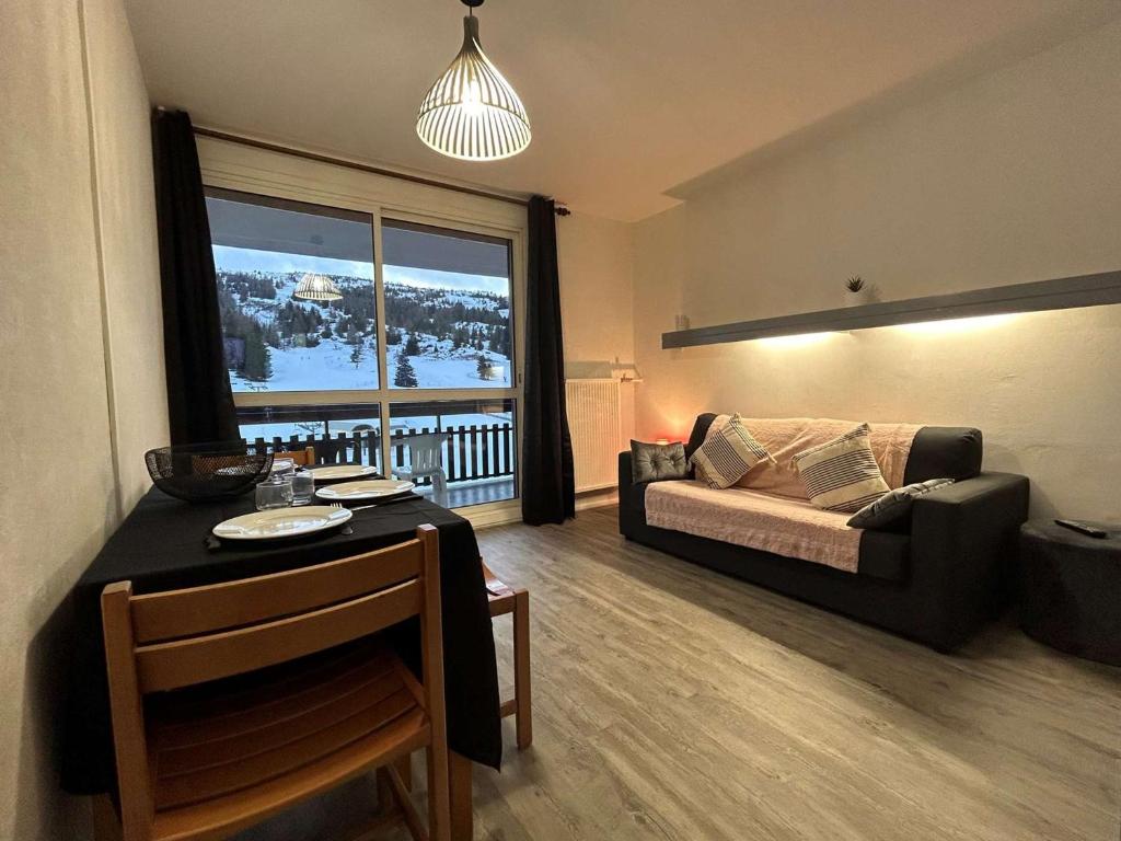 a living room with a couch and a large window at Appartement Le Dévoluy, 1 pièce, 4 personnes - FR-1-525-210 in Le Dévoluy