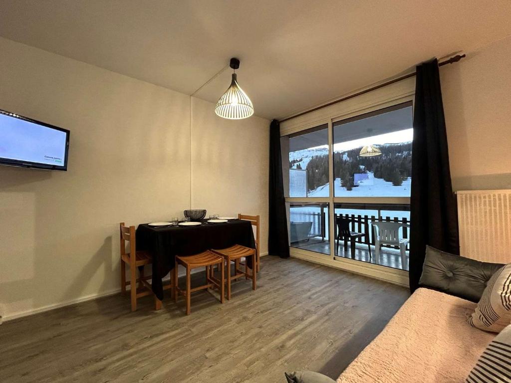 - un salon avec une table à manger et une grande fenêtre dans l'établissement Studio confort pour 4 avec terrasse, parking, wifi et animaux admis - FR-1-525-210, à Saint-Étienne-en-Dévoluy