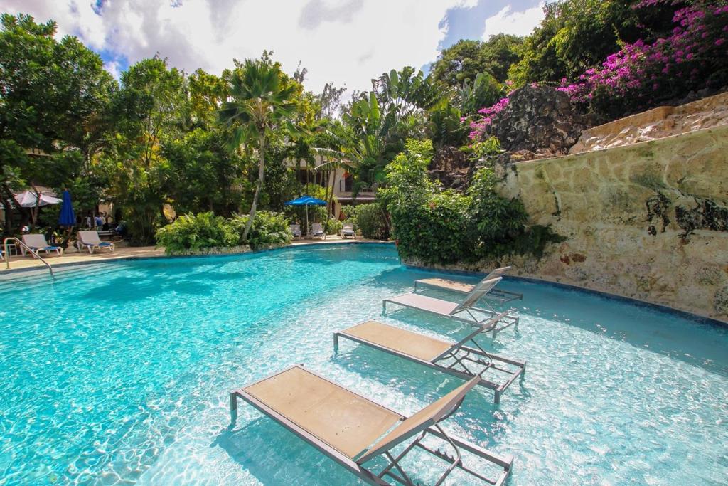 een zwembad met ligstoelen in het water bij Claridges 1 villa in Saint Peter