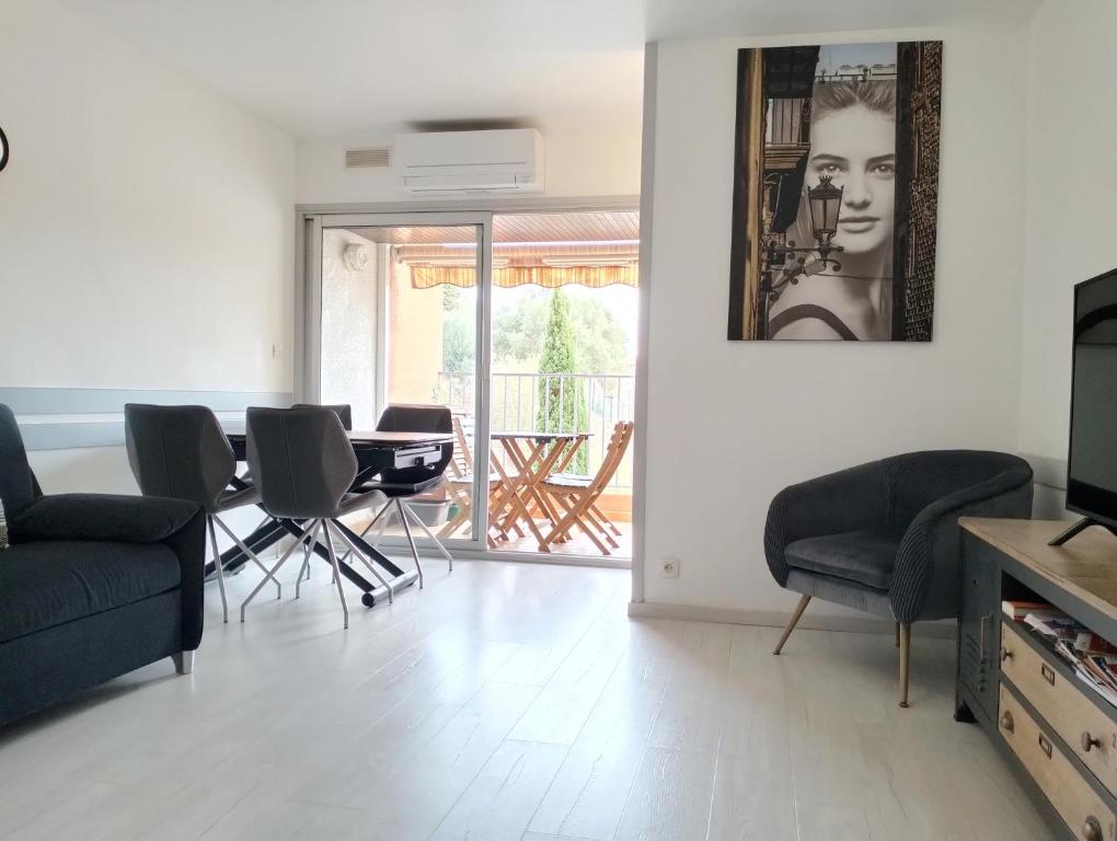 ein Wohnzimmer mit einem Sofa, einem Tisch und Stühlen in der Unterkunft Appartement central avec parking, terrasse et WIFI in Collioure