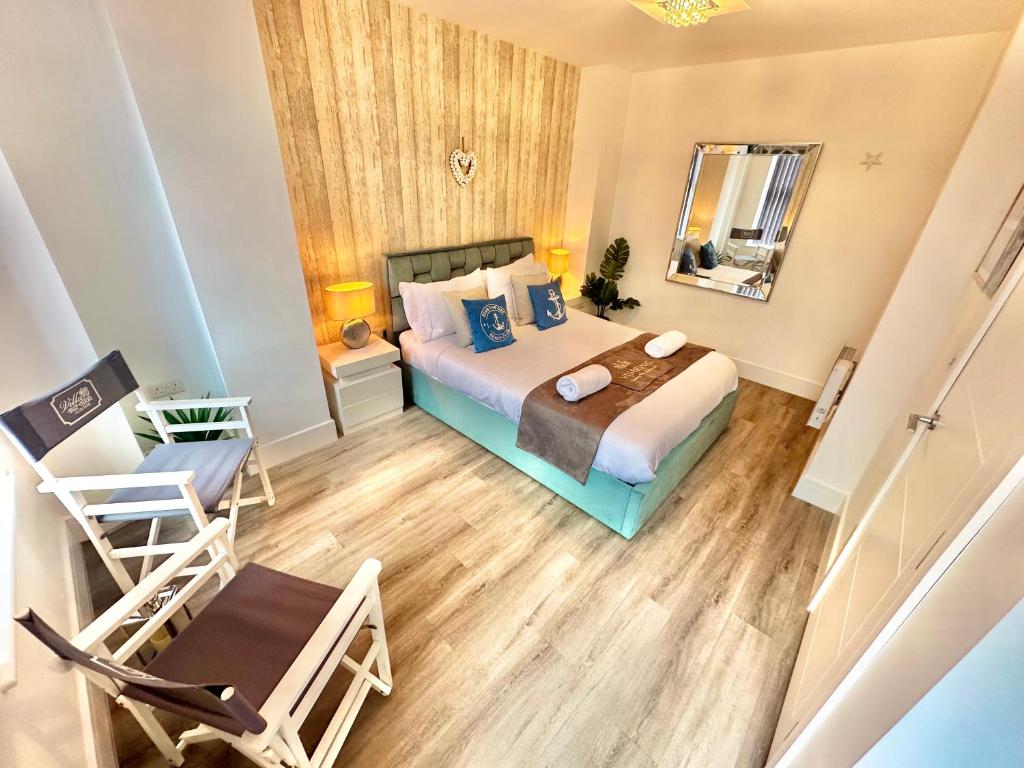 a bedroom with a bed and a chair and a mirror at Coastal Vibes - Stunning Bournemouth Apartment with King Size Bed and Free Parking - Central Location and Close to Beach in Bournemouth