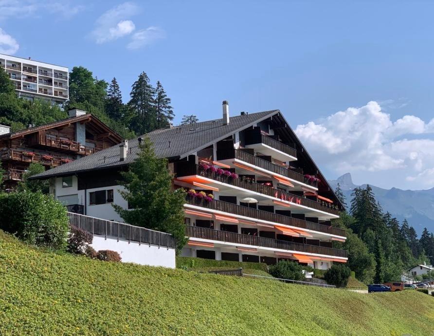a large building with balconies on a hill at Crans Montana spacious 80m2 apartment with stunning view & bus stop outside in Crans-Montana