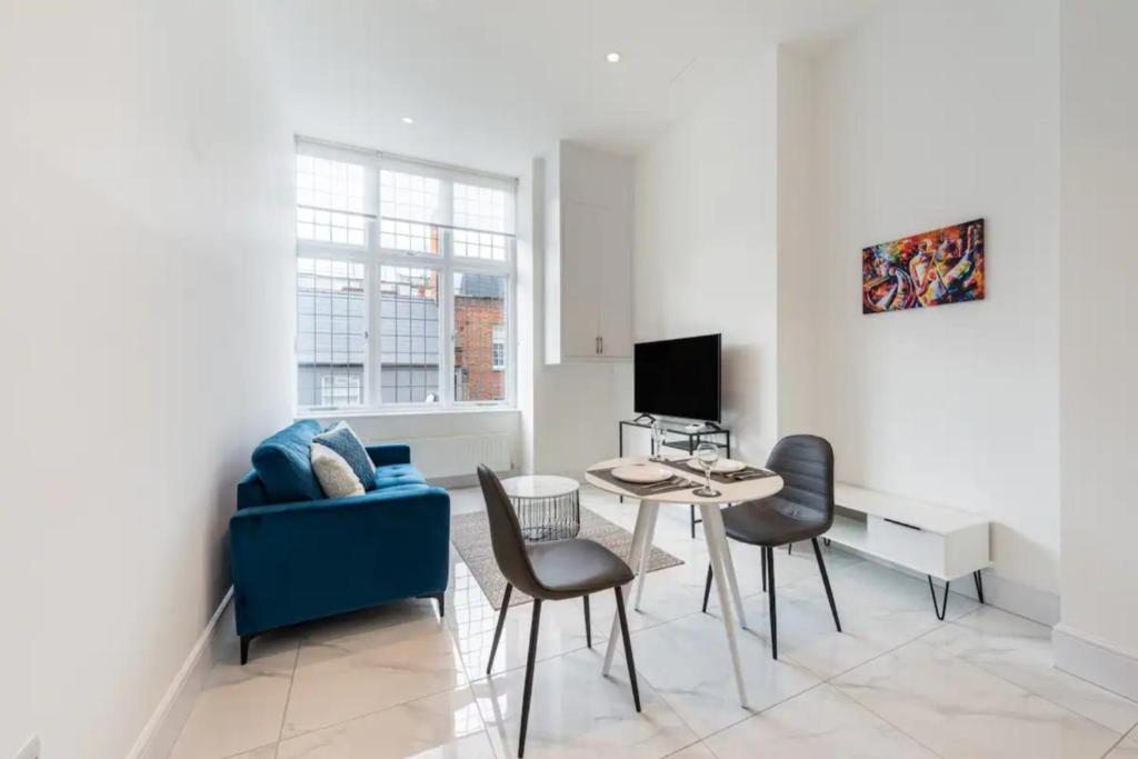 a living room with a blue couch and a table at Luxury Harley Street Apartments in London