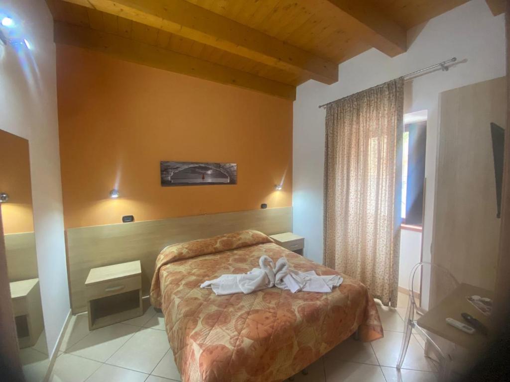 1 dormitorio con 1 cama y 2 toallas blancas en MANDANICI :Borgo Marsalini 2.0, en Barcellona-Pozzo di Gotto