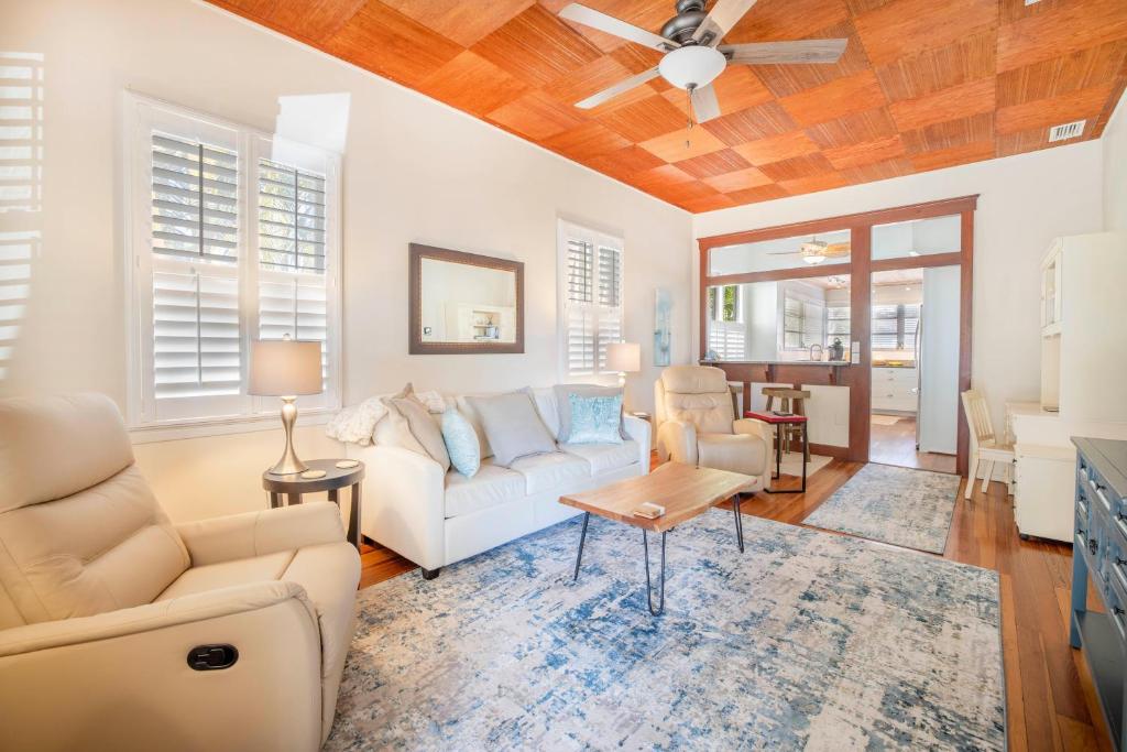 a living room with a couch and a ceiling fan at Pelicans Place - 117A in Siesta Key