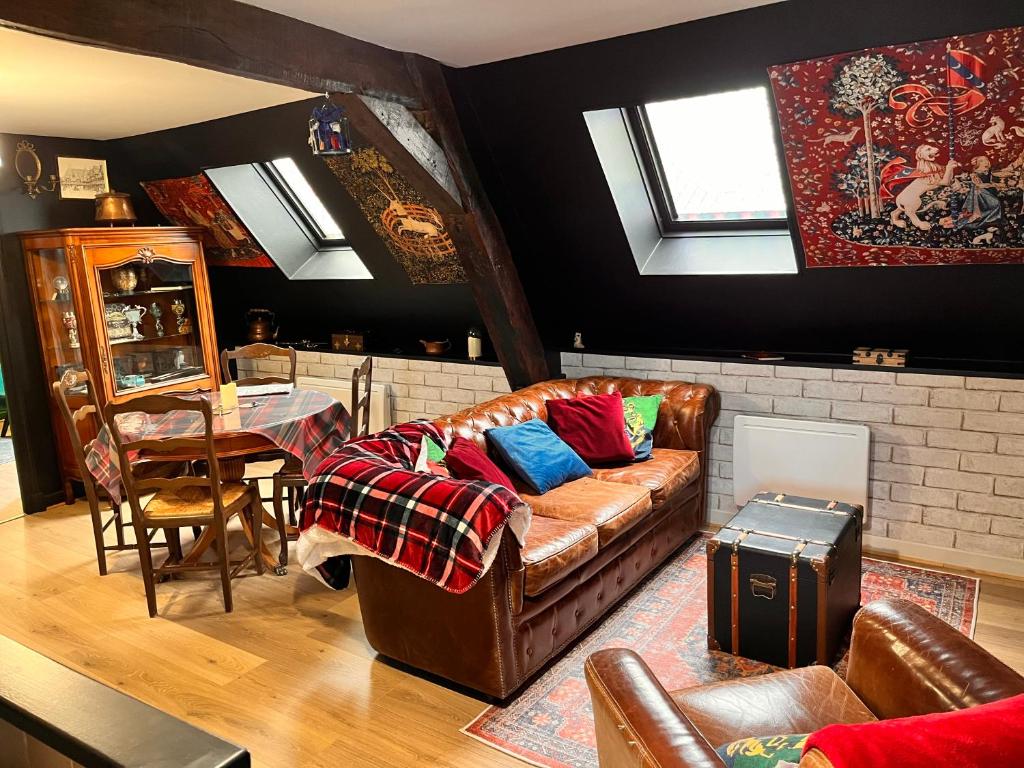 ein Wohnzimmer mit einem Sofa und einem Tisch in der Unterkunft Le gîte du Sorcier 89 in Avallon
