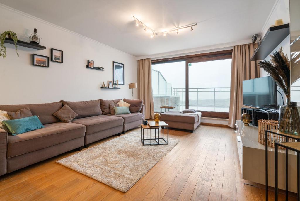 ein Wohnzimmer mit einem Sofa und einem großen Fenster in der Unterkunft Riverside 0902 in Nieuwpoort