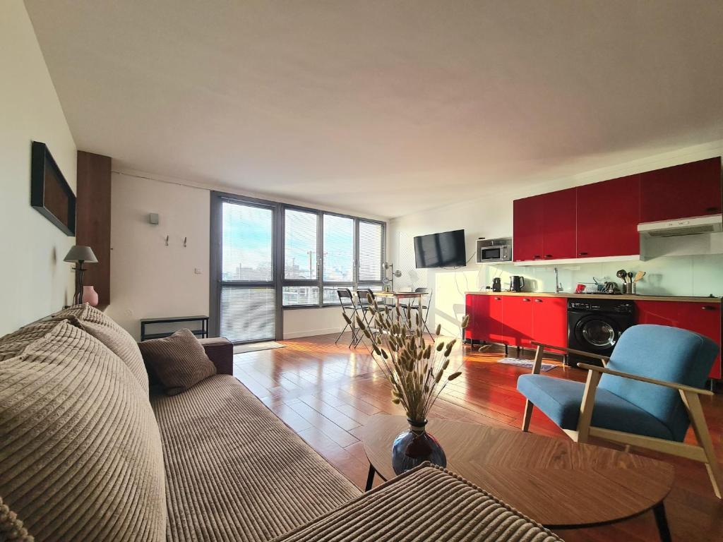 Il comprend un salon avec un canapé et une cuisine. dans l'établissement Bel appartement F2 42 m2, à Ivry-sur-Seine