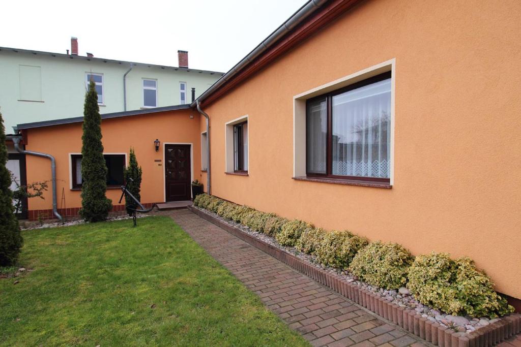 an orange house with a window and a yard at Ferienwohnung Kollwitz in Sassnitz