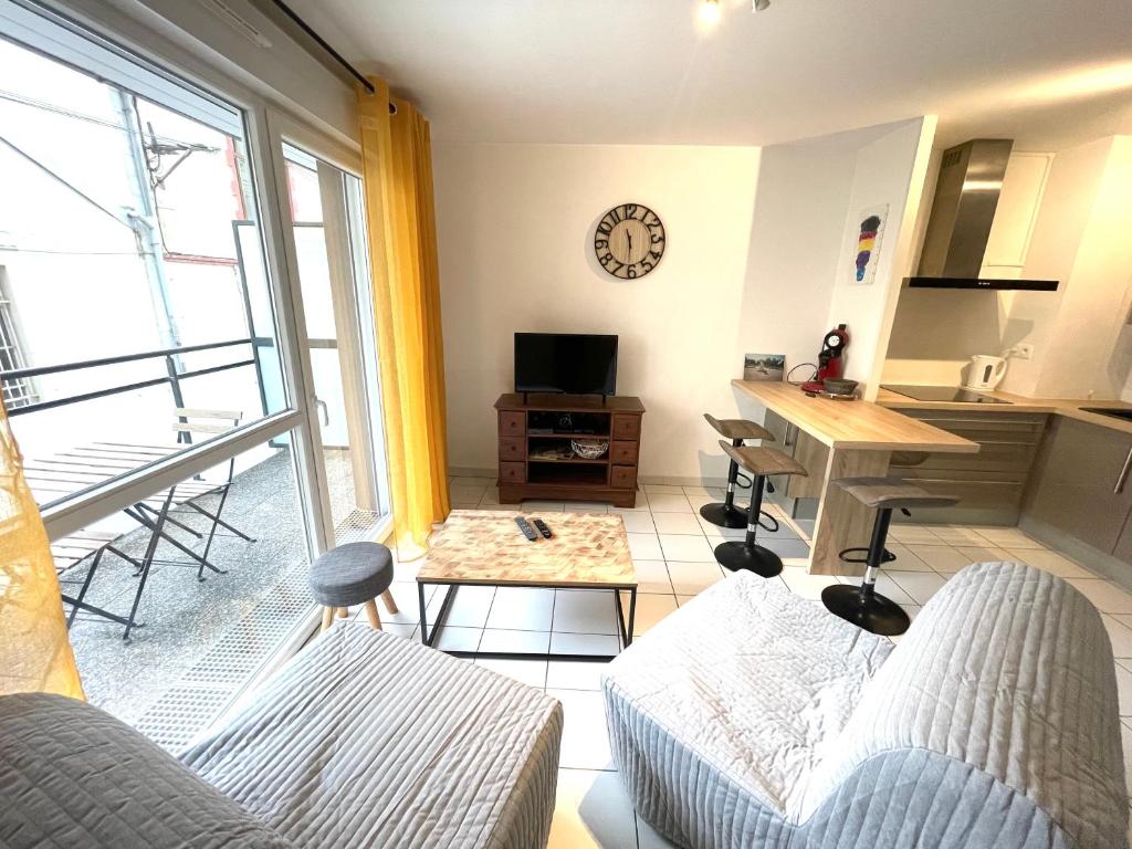ein Wohnzimmer mit einem Sofa und einem Tisch in der Unterkunft Majestic in Besançon