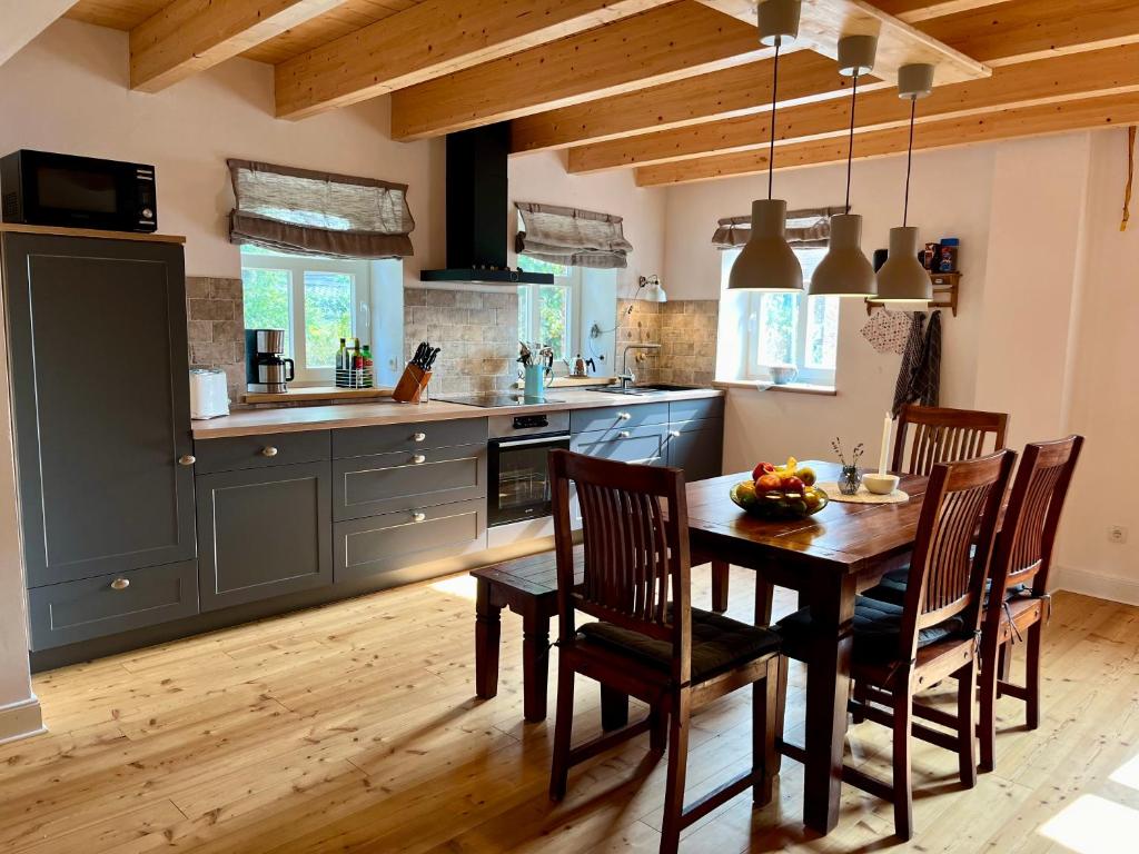 a kitchen with a wooden table and chairs in a kitchen at Haus Deichkind in Krummhörn