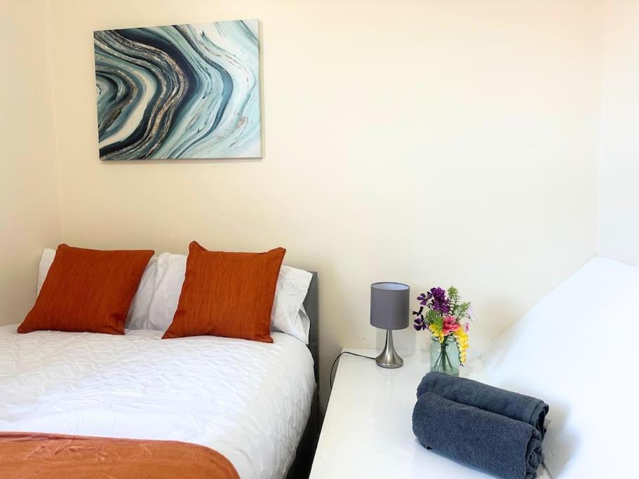 a bedroom with two beds and a vase of flowers at Chic 2-Bed Flat Private Garden SE13 in London