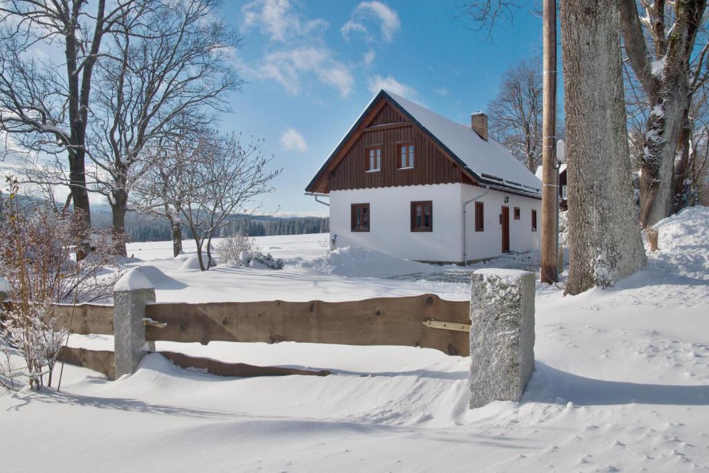 a house in the snow with a wooden fence at Chalupa Rejvíz in Rejvíz