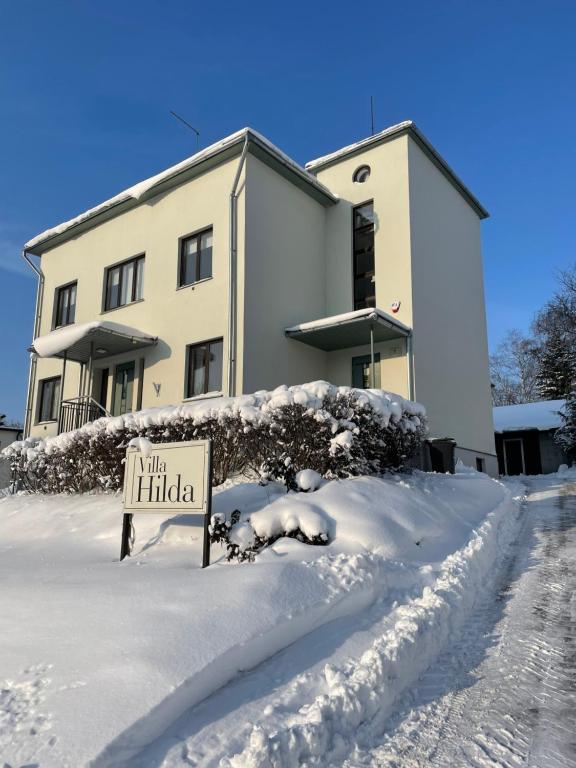 ein Schild im Schnee vor einem Gebäude in der Unterkunft Hilda Villa in Viljandi