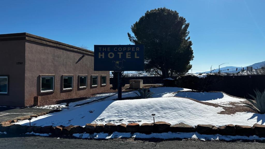 a sign for the corner hotel in the snow at The Copper Hotel - SureStay Collection by Best Western in Camp Verde