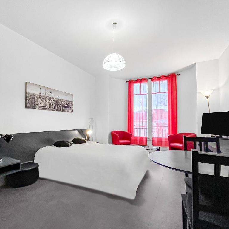 - une chambre avec un lit, une table et des chaises rouges dans l'établissement Le Nid Thermal, à Vichy