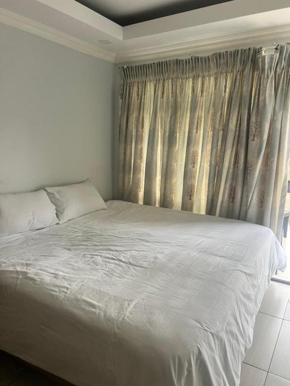 a bedroom with a white bed and a window at Luband Guest House 
