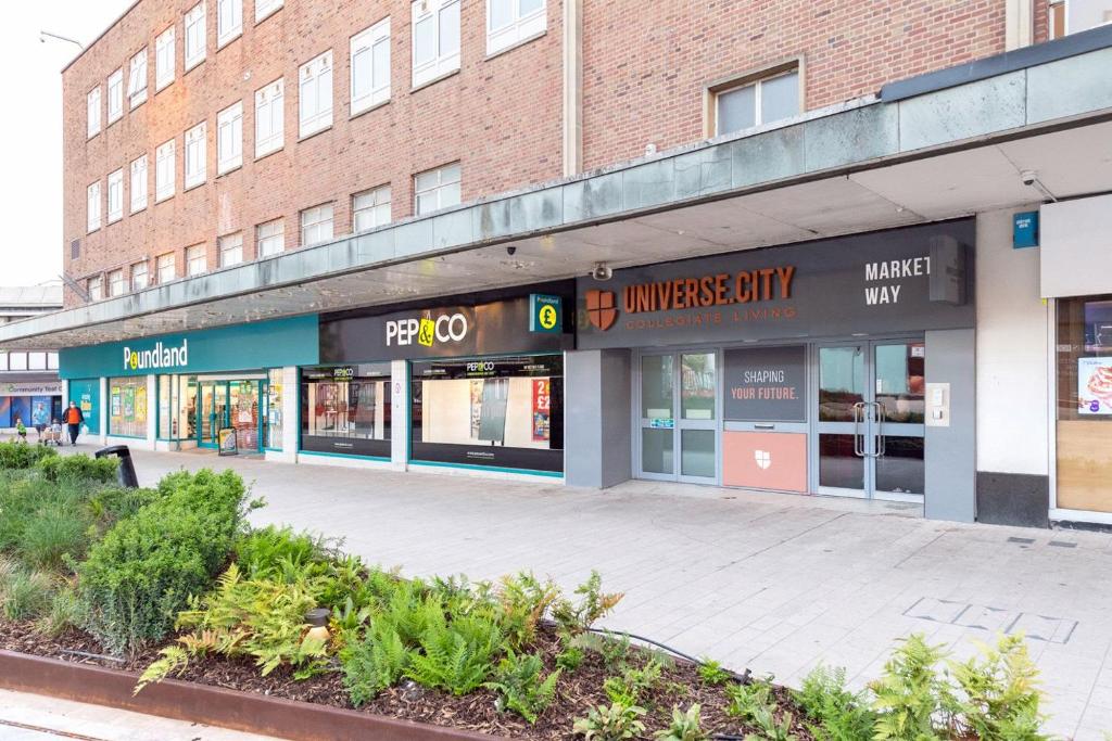 una tienda frente a un edificio de ladrillo en For Student Only City Living Studios in the heart of Coventry at Market Way en Coventry