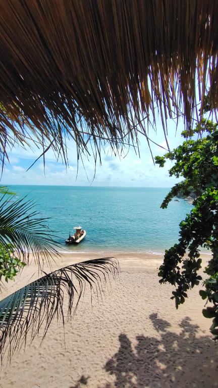 a boat on a beach near the ocean at Why Nam Beach in Haad Yuan