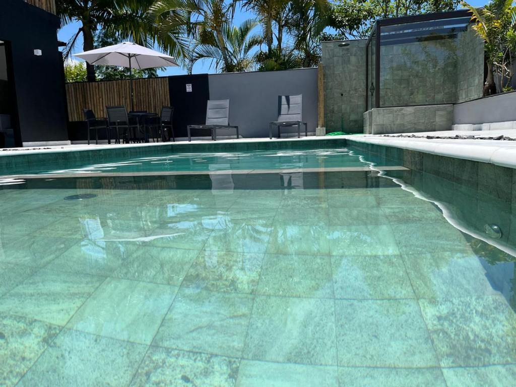 una piscina de azul claro en Palulu Flat - Conforto e Conveniência Garantidos - Ar Condicionado - Área de Lazer com Piscina e Sauna - Garagem Subterrânea - Serviço de Praia en Juquei