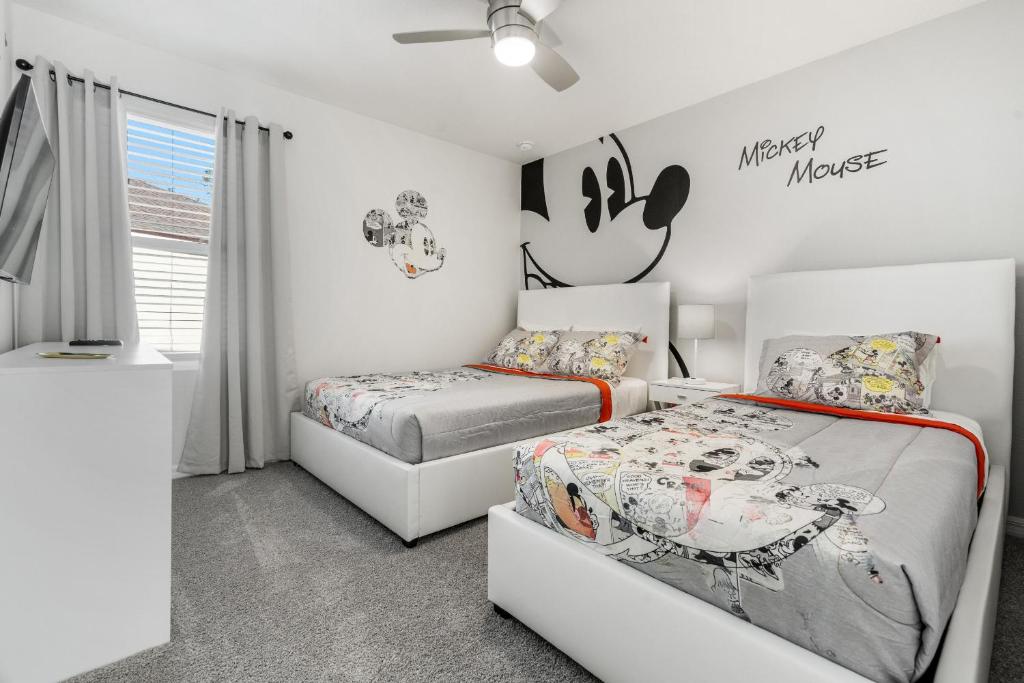 a bedroom with two beds and a couch at Amazing Villas 20 minutes away from Disney! in Kissimmee