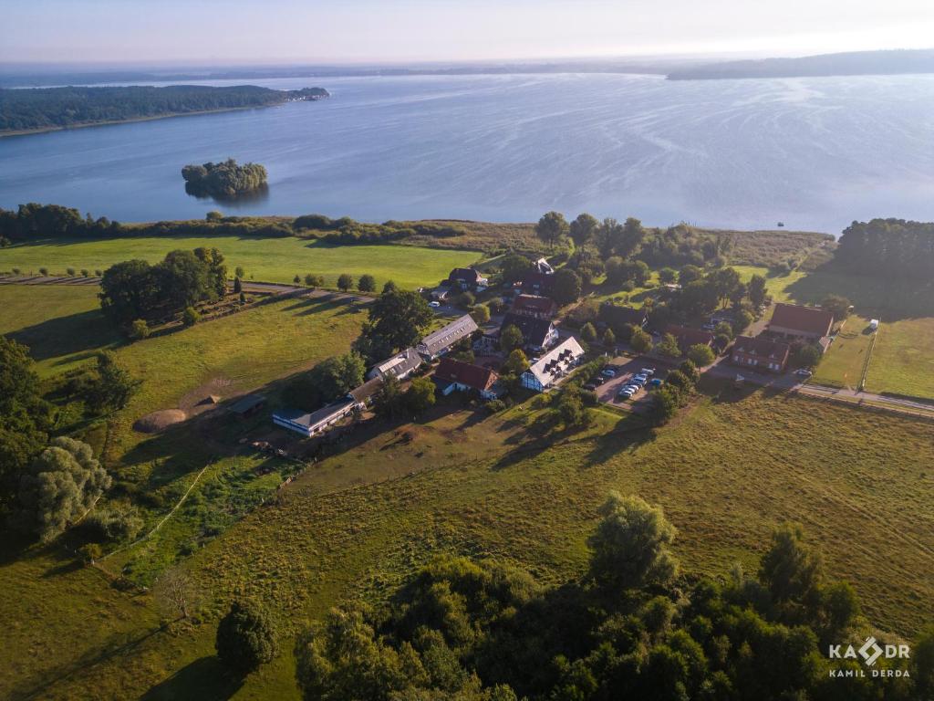 eine Luftansicht eines Hauses auf einem Hügel neben dem Wasser in der Unterkunft Landhotel Rose am Plauer See garni in Plau am See