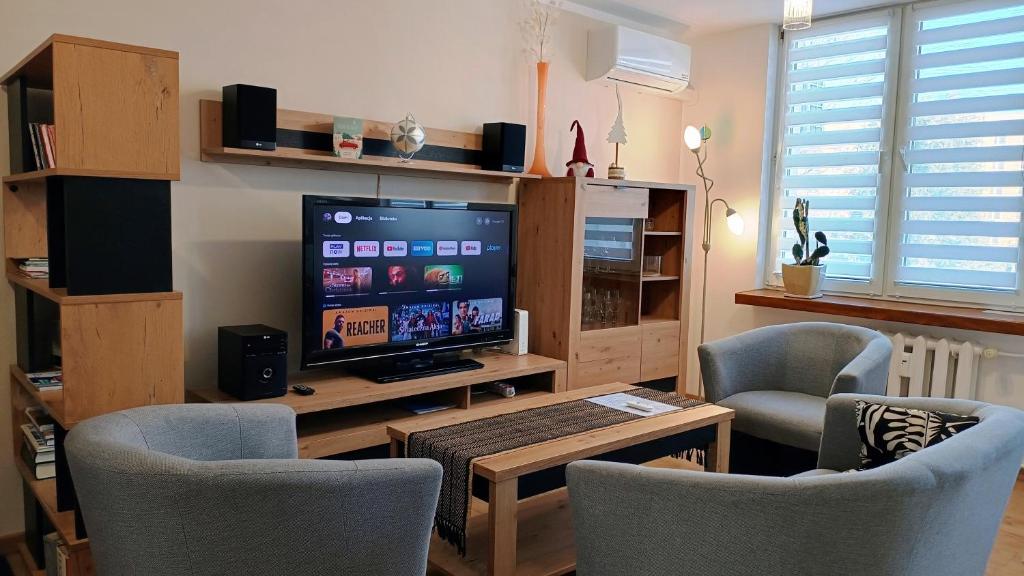 a living room with a tv and two chairs and a table at Apartament Nadstawna klimatyzowany in Biłgoraj