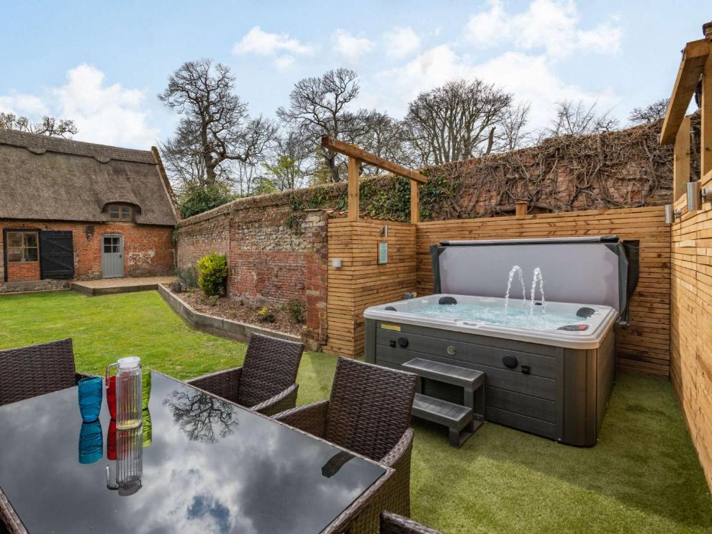 a backyard with a hot tub in a yard at 3 Bed in Wroxham 86387 in Swanton Abbot