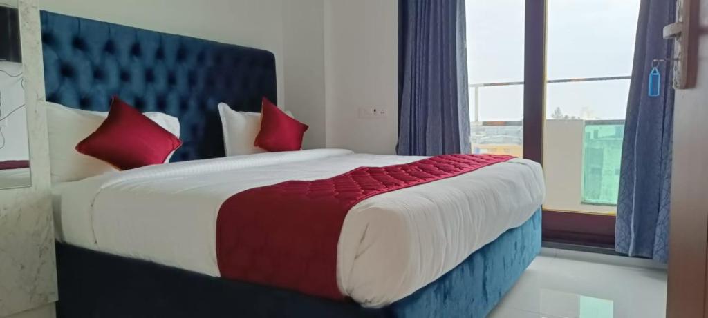 um quarto com uma cama grande e almofadas vermelhas em NMS GRAND VIEW TOWER em Pondicherry