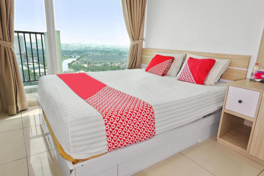 uma cama num quarto com uma grande janela em OYO 93432 Tree Room Hotel em Kebonnanas