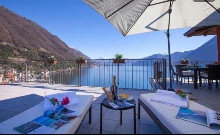 阿爾傑尼奧的住宿－Luxury Penthouse with Big Terrace，露台配有桌子和遮阳伞,享有水景