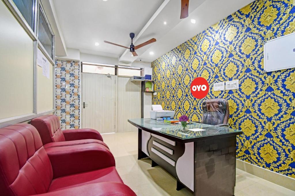 a waiting room with red chairs and a desk with a stop sign at SPOT ON Lewis Paradise in Bhubaneshwar