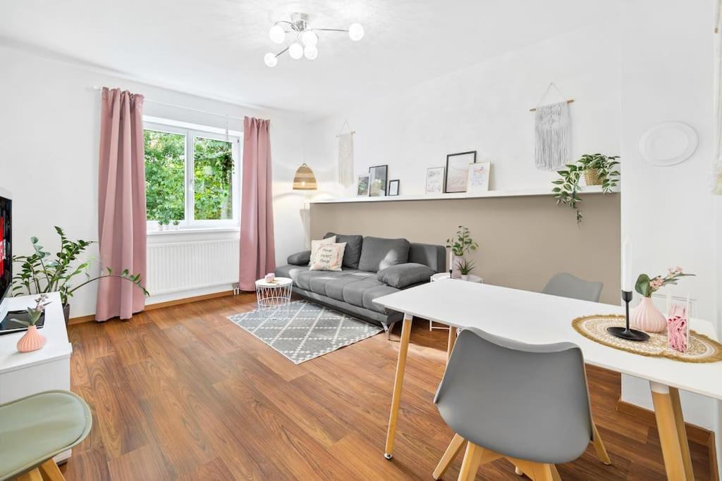 sala de estar blanca con mesa y sofá en Ruhiges Apartment in der Nähe von Park und Krankenhaus mit gratis Parkplatz en Graz