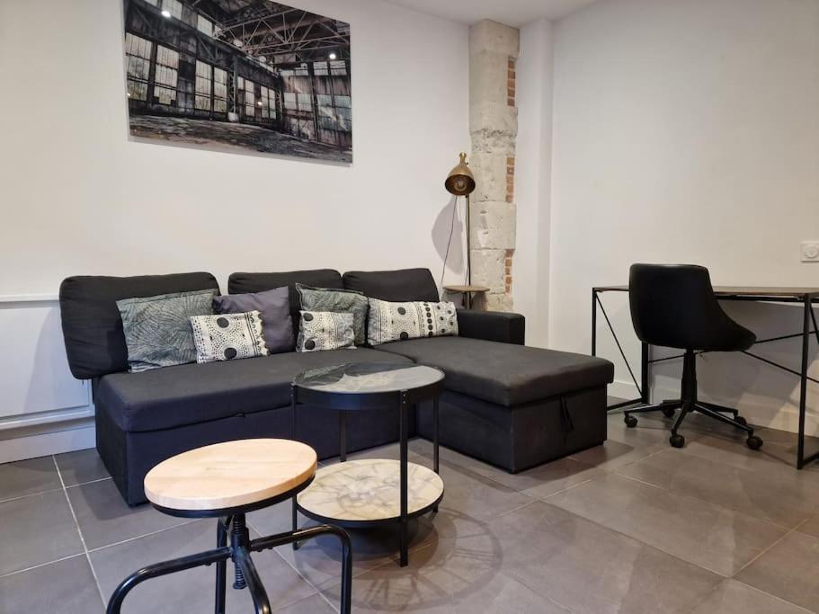 a living room with a couch and a table and chairs at Appartement cœur de Doutre in Angers