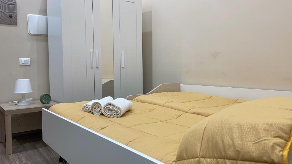 ein Bett mit zwei Schuhpaaren darauf in der Unterkunft Nonna Concetta B&B Nocera - Vicino Tribunale di Nocera - Ristrutturato 2022 in Nocera Inferiore